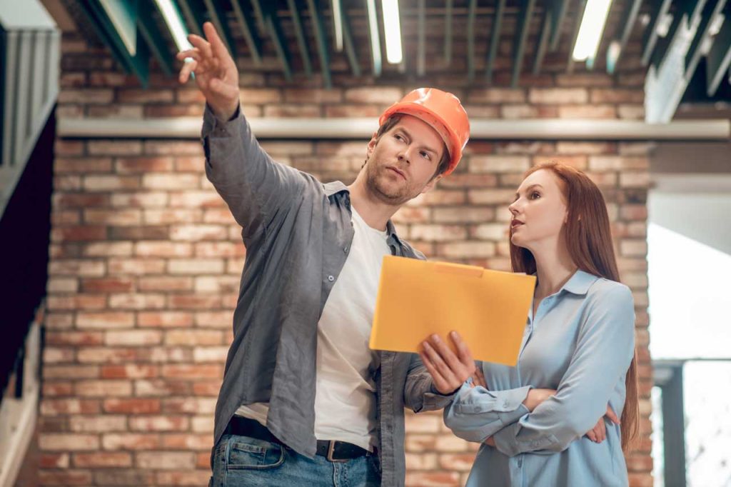 Satisfied homeowner discussing gutter options with a contractor.