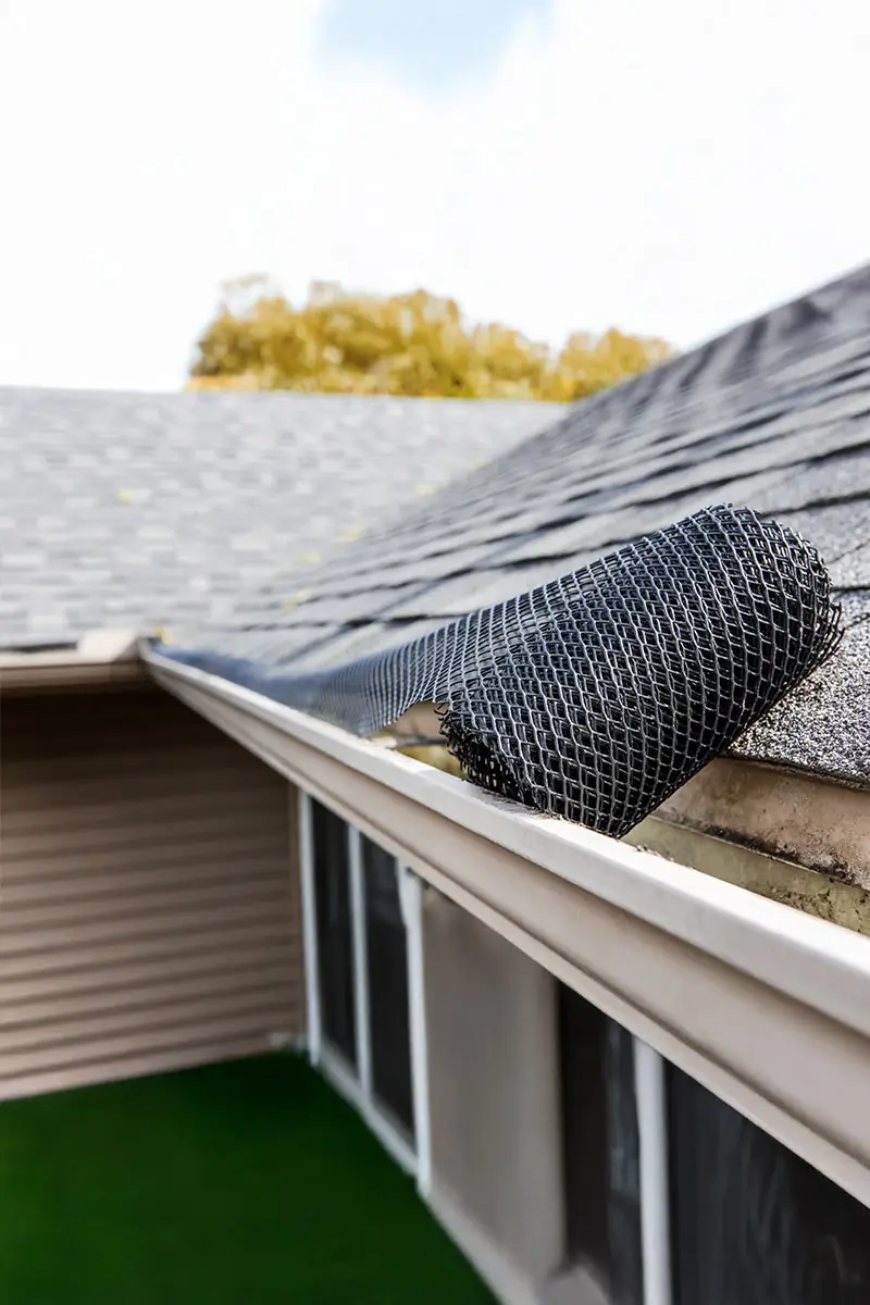 Roll of plastic mesh guard over gutter on a roof to keep it free of leaves and debris.